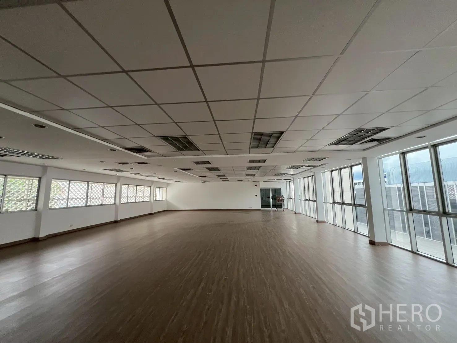 Office Space for rent in Watthana, Bangkok - Bright open workspace with grid ceiling, air vents and floor-to-ceiling windows.