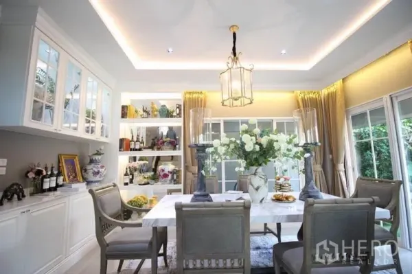 Detached House for rent or sale in Lat Phrao, Bangkok - Elegant dining room featuring a marble-top table, pendant light, built-in shelves and garden views.