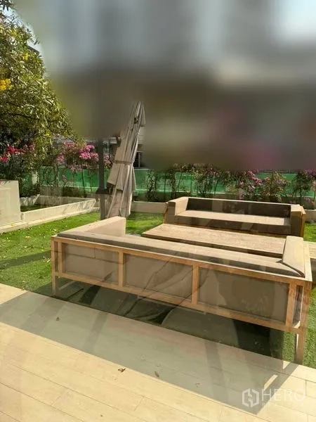 Townhouse for rent in Watthana, Bangkok - Ground-floor garden with outdoor sofa seating and green lawn.