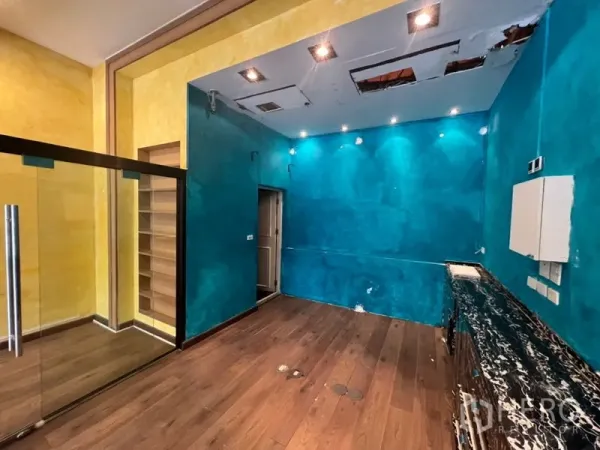 Retail Space for rent in Watthana, Bangkok - Back service zone with teal walls, wood flooring, countertop space, and ceiling access panels.
