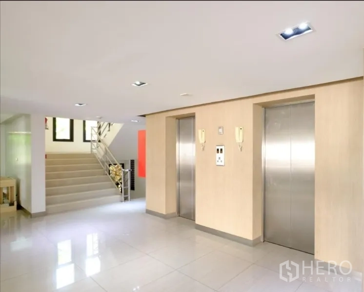 Office Space for rent in Chatuchak, Bangkok - Modern lobby with two stainless-steel elevators and a stairwell in a Bangkok office building.