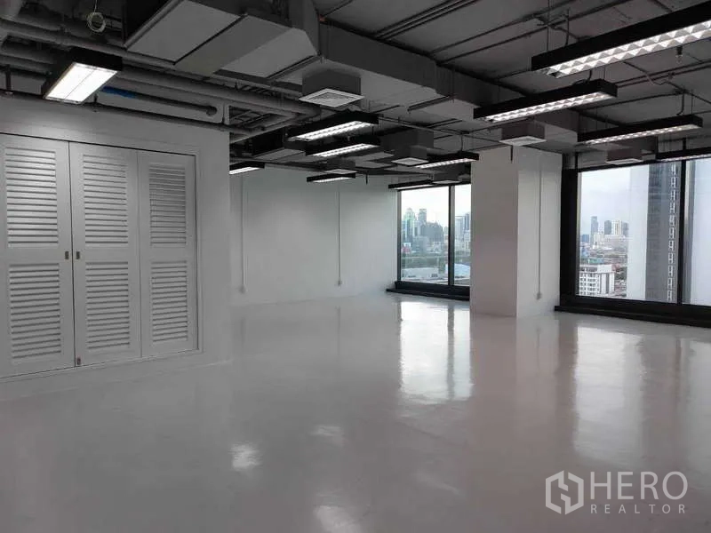 办公空间 出租 - 明亮转角办公区，带百叶储物柜与落地窗俯瞰曼谷。