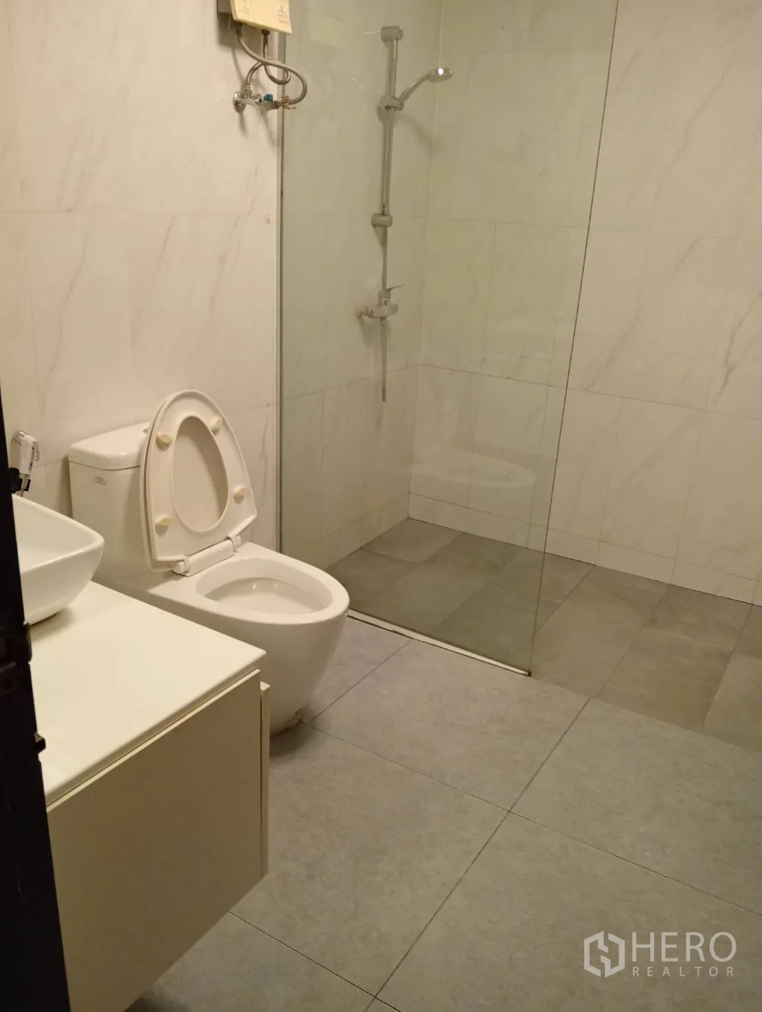 Home Office for rent in Khlong Toei, Bangkok - Modern bathroom with glass shower enclosure, vanity and toilet.