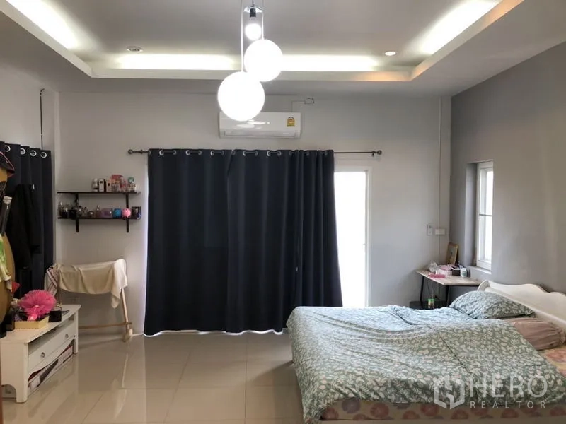 Detached House for sale in Lam Luk Ka, Pathum Thani - Master bedroom with bed, pendant lights and dark curtains.