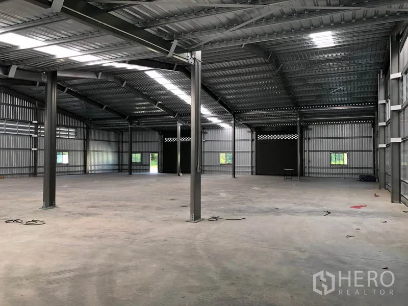 Warehouse for rent in Pak Kret, Nonthaburi - Wide storage floor featuring steel frame structure and natural light panels.