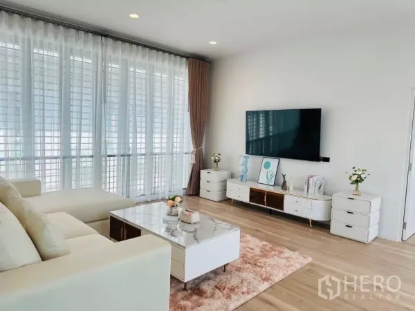 Detached House for rent or sale in Bang Kapi, Bangkok - Living area view showing marble coffee table, TV console and floor-to-ceiling windows.