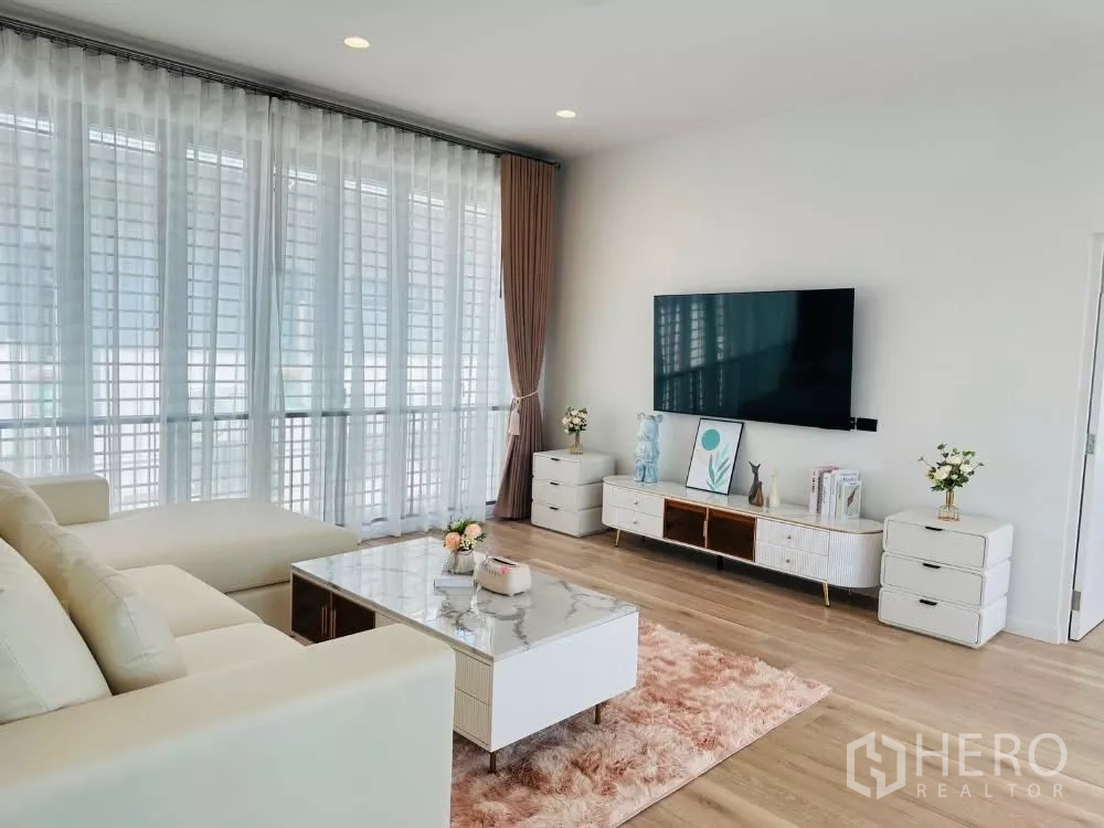 Detached House for rent or sale in Bang Kapi, Bangkok - Living area view showing marble coffee table, TV console and floor-to-ceiling windows.