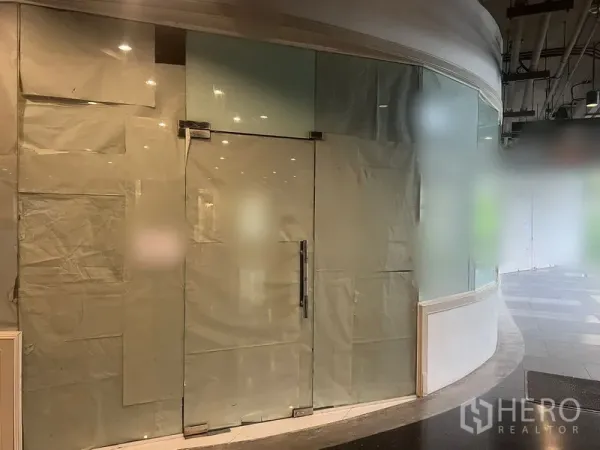 Retail Space for rent in Watthana, Bangkok - Glass shopfront on a curved corner facing the walkway with spotlighted ceiling above.
