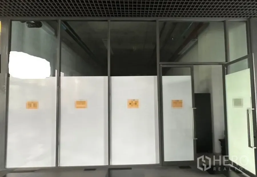 Retail Space for rent in Khlong Toei, Bangkok - Full-height glass shopfront with framed door and frosted panels at a vacant retail space.