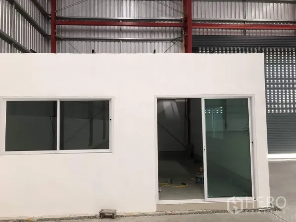 Warehouse for rent in Pak Kret, Nonthaburi - Internal office room with sliding glass door and windows inside the warehouse.