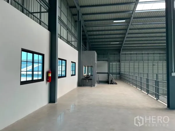Warehouse for rent in Bang Phli, Samut Prakan - Mezzanine corridor with windows, railing, lighting, and a fire extinguisher.
