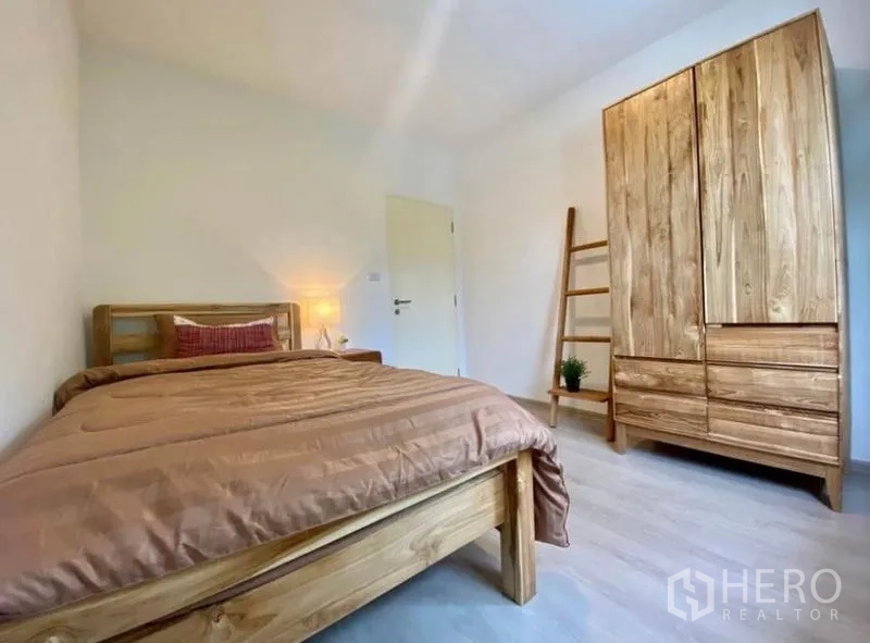 Townhouse for rent in Bang Phli, Samut Prakan - Cozy secondary bedroom with wooden bed, tall wardrobe and ladder shelf.