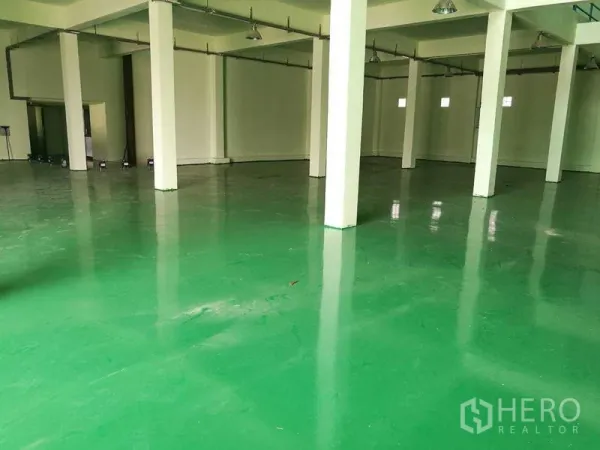 工厂 出租在Mueang Samut Sakhon, Samut Sakhon - 宽敞生产车间，绿色环氧地坪、白色立柱与高吊顶照明。