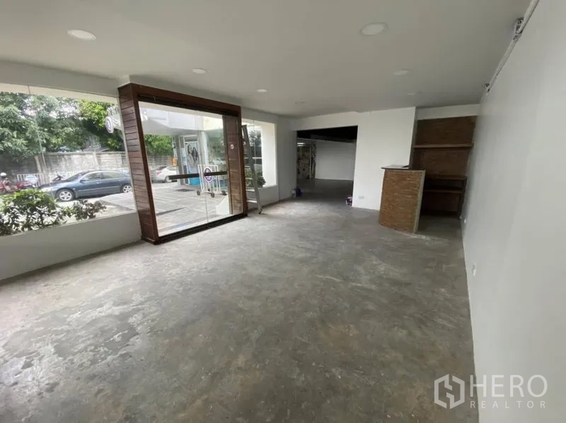 Retail Space for rent in Bangkok - Bright storefront featuring large glass entrance and display windows with open-plan sales area and concrete flooring.