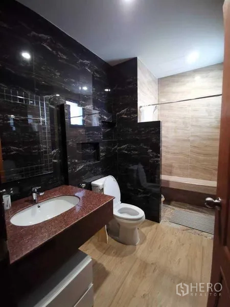 Detached House for rent in Prawet, Bangkok - Second bathroom with black marble wall tiles, granite countertop and separate shower with bench.
