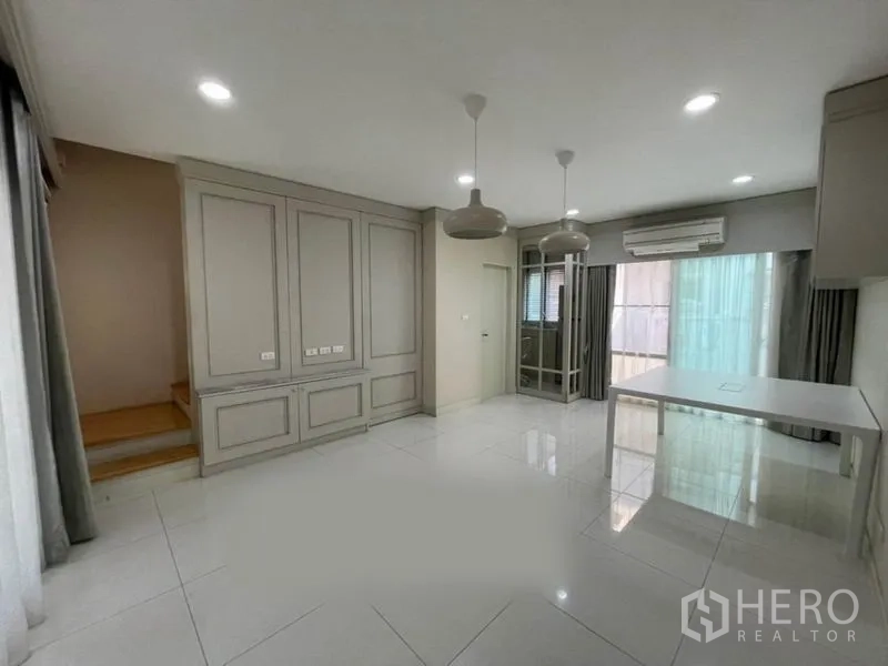 Townhouse for sale in Suan Luang, Bangkok - Bright open-plan living area with built-in cabinetry, pendant lights and sliding doors in a Suan Luang townhouse.