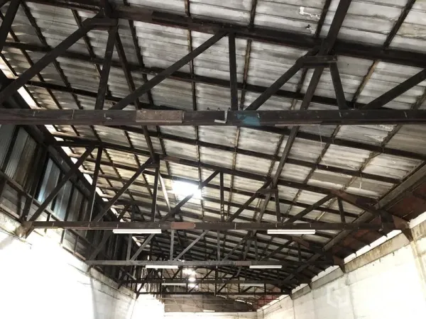 Retail Space for rent in Khlong Toei, Bangkok - Close-up of the metal roof showing exposed steel trusses and strip lighting that create a high ceiling.