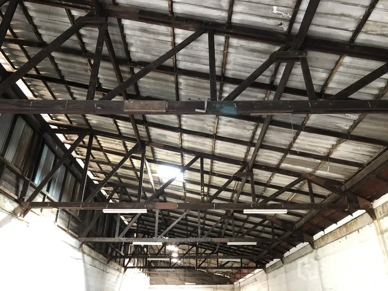 Retail Space for rent in Khlong Toei, Bangkok - Close-up of the metal roof showing exposed steel trusses and strip lighting that create a high ceiling.