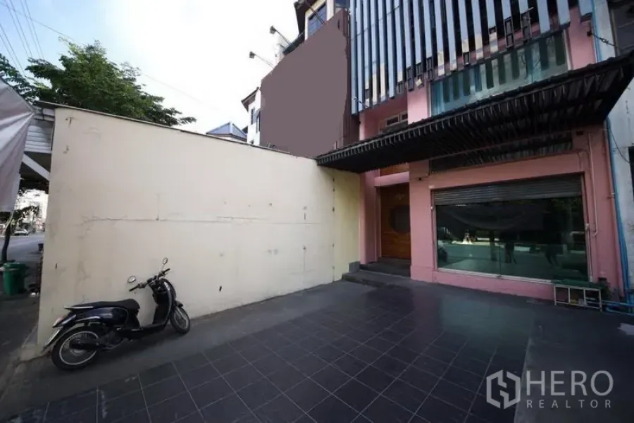 Home Office for rent or sale in Huai Khwang, Bangkok - Front courtyard with tiled parking and glass-front home office facade in Huai Khwang, Bangkok.