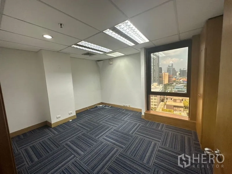 Office Space for rent in Khlong Toei, Bangkok - Cozy private office with window view and blue carpet tiles.