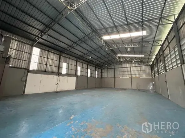 Warehouse for rent in Pathum Thani - Empty warehouse floor showing ventilation louvers, insulated roof panels and a wide clear span.