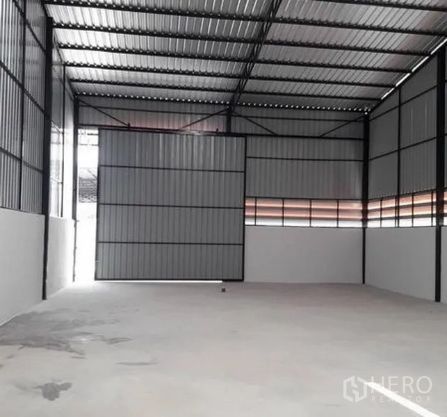 货栈 出租在Lam Luk Ka, Pathum Thani - 宽敞仓库，超高金属滑门半开，金属夹芯墙与混凝土地面。