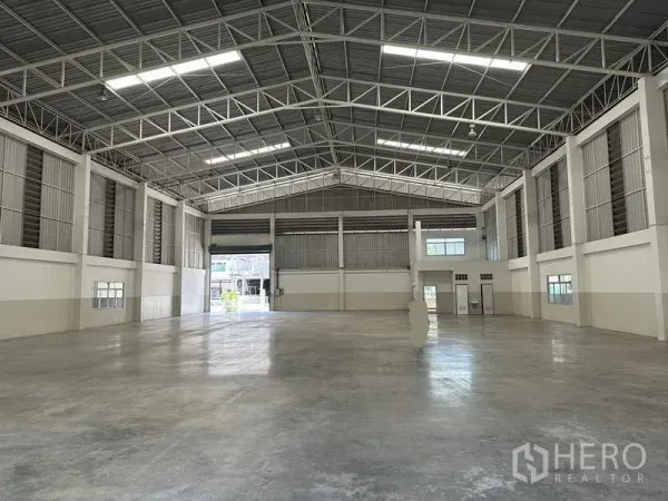工厂 出租 - 开阔的工业室内空间，超大跨距结构，照明明亮，多个卷闸出入口。