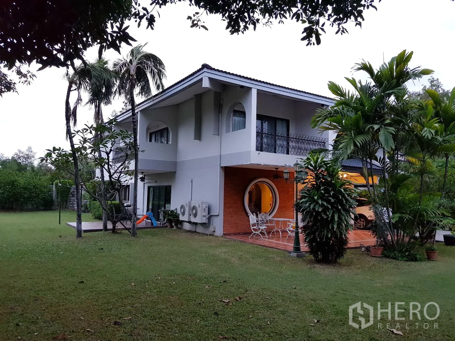 Detached House for rent in Khan Na Yao, Bangkok - Two-storey detached house with covered terrace, round window and large lawn amid tropical trees in Khan Na Yao, Bangkok.