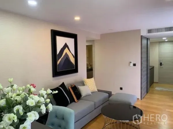 Condominium for rent or sale in Pathum Wan, Bangkok - Open-plan lounge with recessed lighting, sofa set and entry corridor inside a Bangkok condominium.