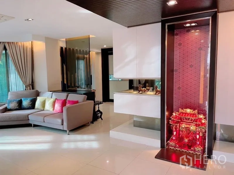 Detached House for rent or sale in Prawet, Bangkok - Bright open-plan living room with sectional sofa, glossy tile floor and built-in display cabinet.