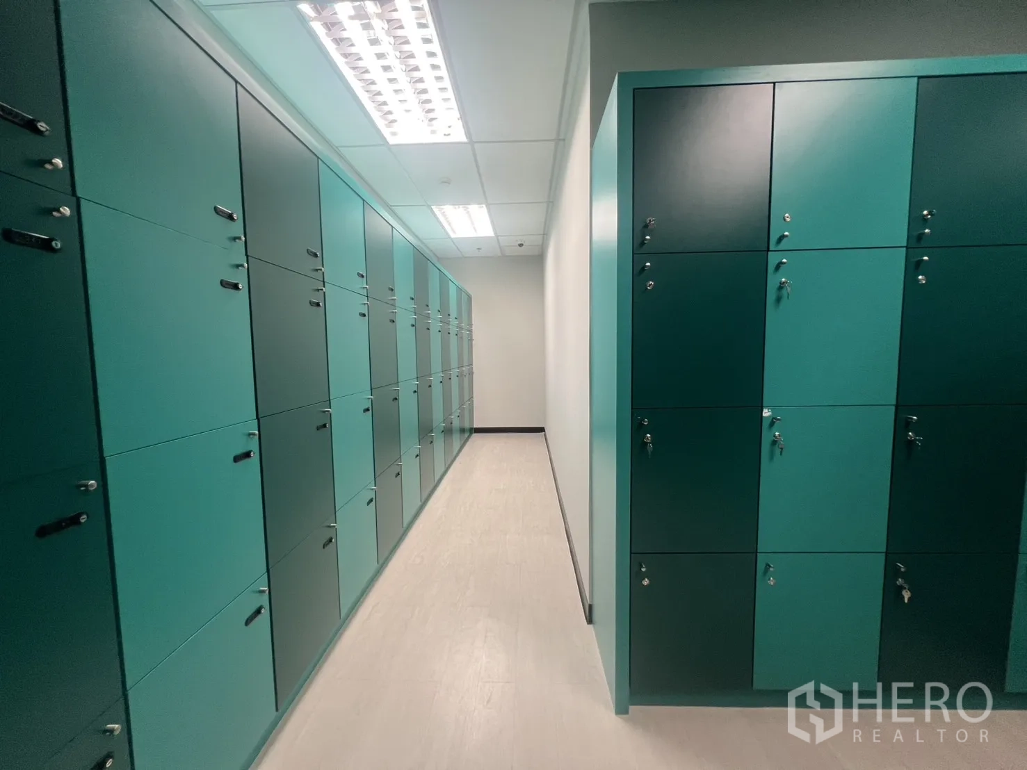 办公空间 出租在Huai Khwang, Bangkok - 走廊两侧为青绿色员工储物柜，带独立锁具。