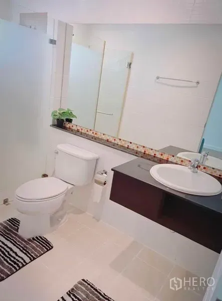 Townhouse for rent in Suan Luang, Bangkok - Modern bathroom with glass shower screen, long mirror, vanity and toilet
