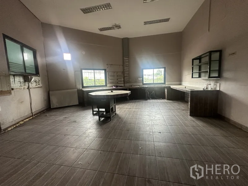 Standalone for rent in Prawet, Bangkok - Spacious kitchen or workroom with counters around the walls and high ceiling.