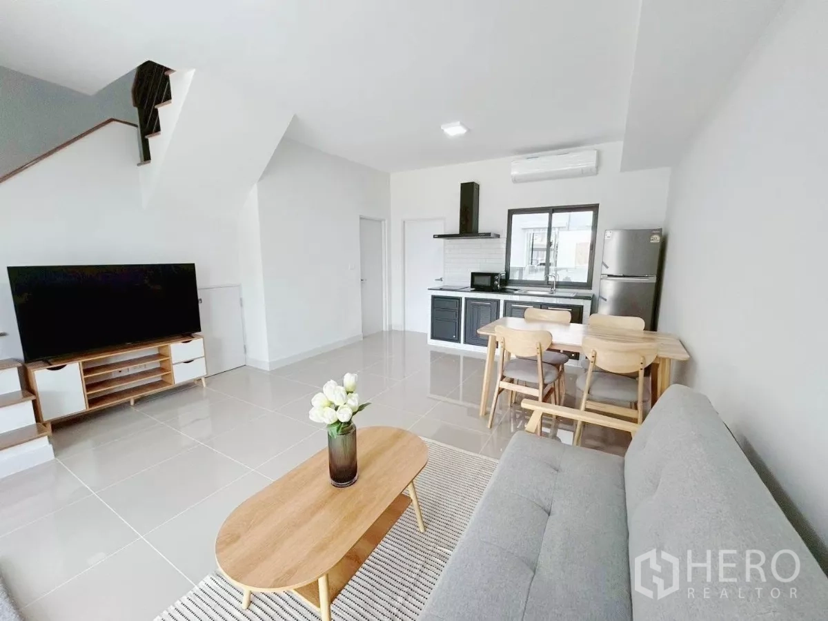 Townhouse for rent in Bang Phli, Samut Prakan - Bright open-plan living, dining and kitchen with TV, sofa and tiled floors.