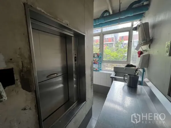 Shophouse for rent or sale in Khlong Toei, Bangkok - Stainless dumbwaiter service lift beside a prep counter and bright window.