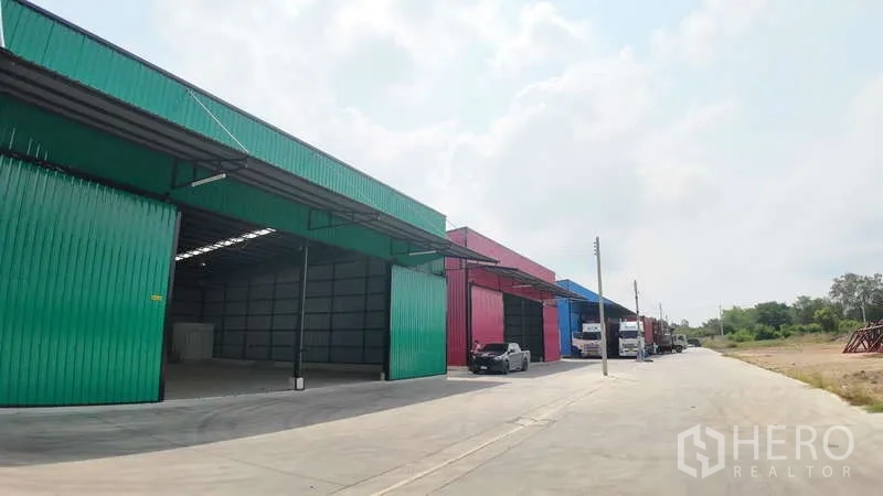Warehouse for rent in Mueang Chachoengsao, Chachoengsao - Perspective of colorful warehouse units featuring canopies, loading areas, and ample truck turning space.