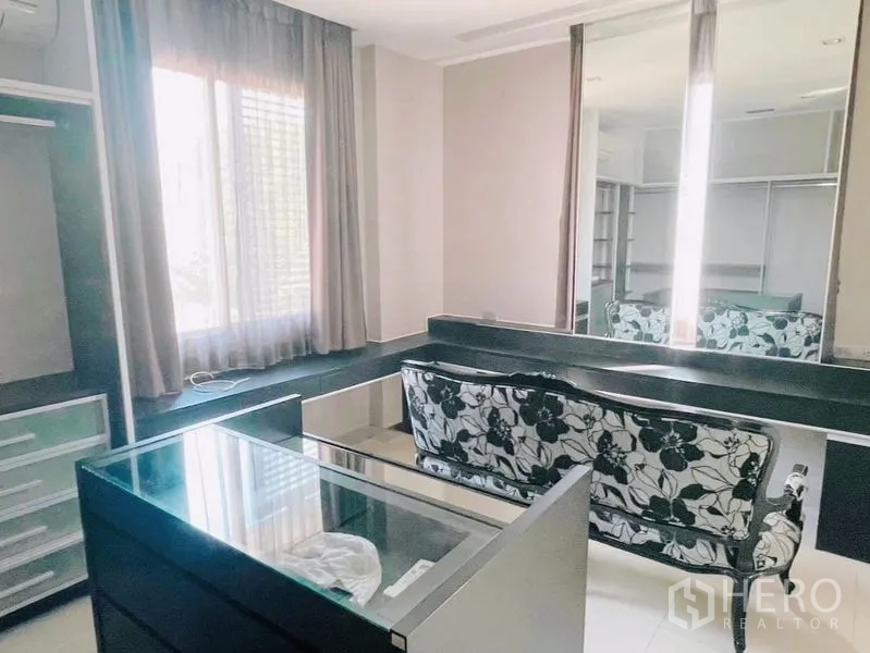 Detached House for rent or sale in Prawet, Bangkok - Walk-in closet with vanity, large mirrors and seating bench.