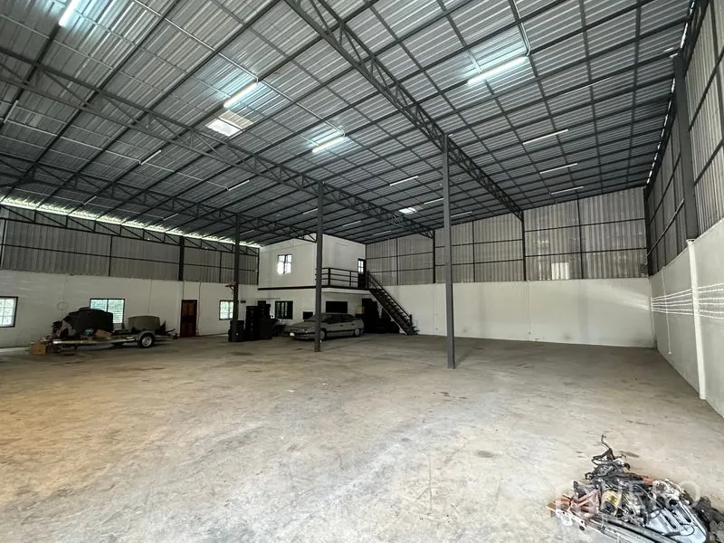 Warehouse for rent in Thanyaburi, Pathum Thani - Spacious warehouse interior with high steel truss roof, concrete floor and mezzanine office.