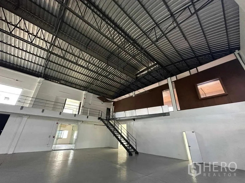 Warehouse for rent in Phra Khanong, Bangkok - Warehouse interior with mezzanine offices, high metal roof and ample natural light.