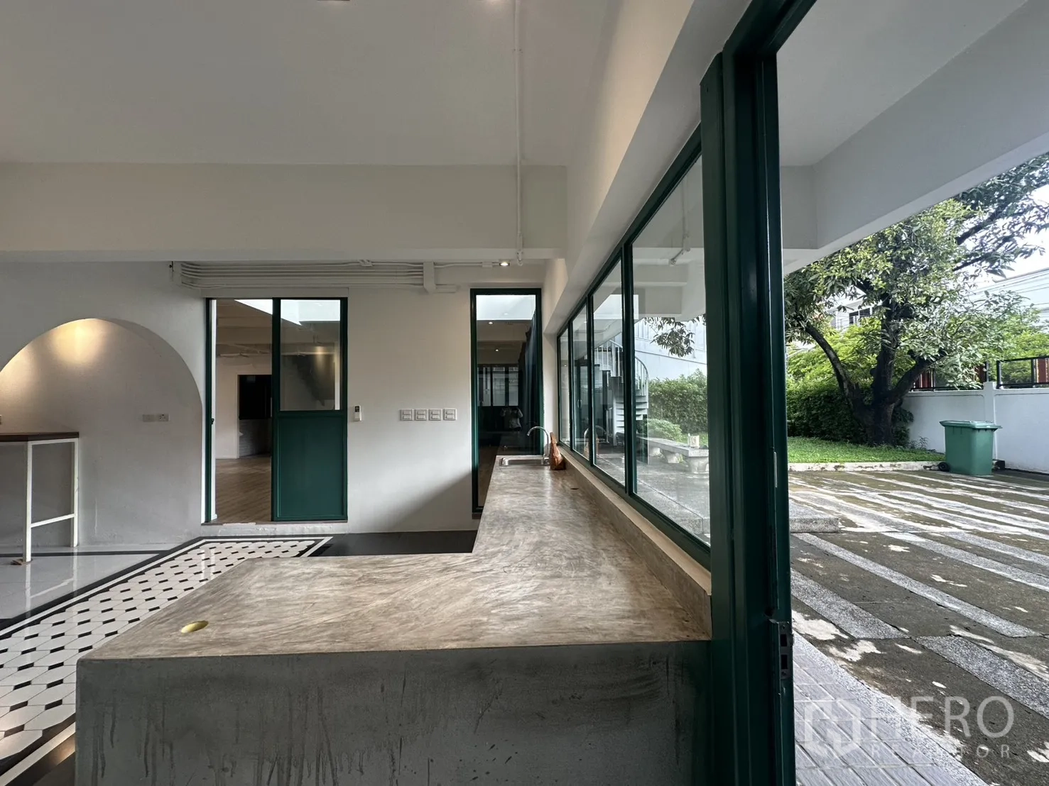 带办公室的家 出租或出售在Phra Khanong, Bangkok - 混凝土茶水间台面，推拉窗通向花园与车道