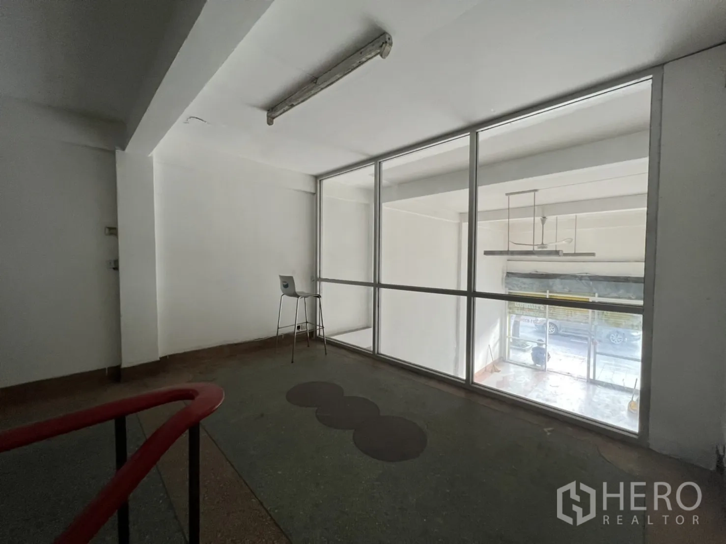 Shophouse for rent in Phra Khanong, Bangkok - Mezzanine office area with large interior glass window overlooking the front retail space.