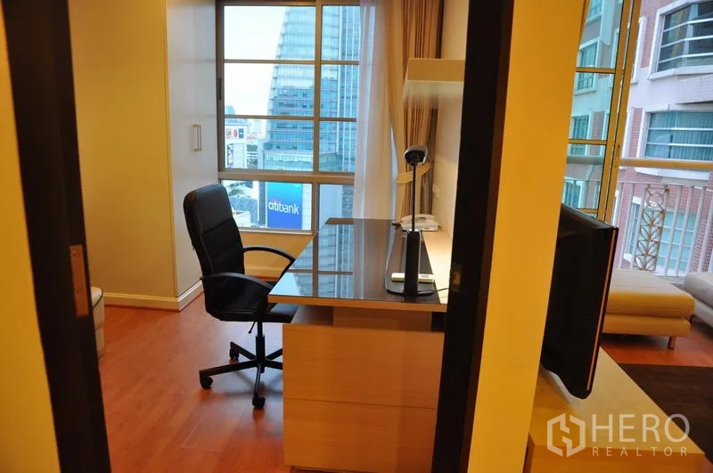 Condominium for rent or sale in Khlong Toei, Bangkok - Window-side work-from-home corner with desk and office chair overlooking the skyline.