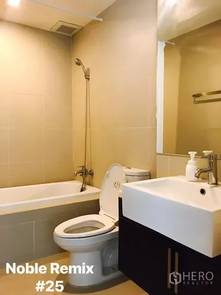 Condominium for rent in Khlong Toei, Bangkok - Modern bathroom featuring a bathtub with handheld shower, toilet and square basin with mirror.