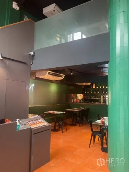 Shophouse for rent in Watthana, Bangkok - Dining room with mezzanine level above and dark ceiling, air-conditioning installed.