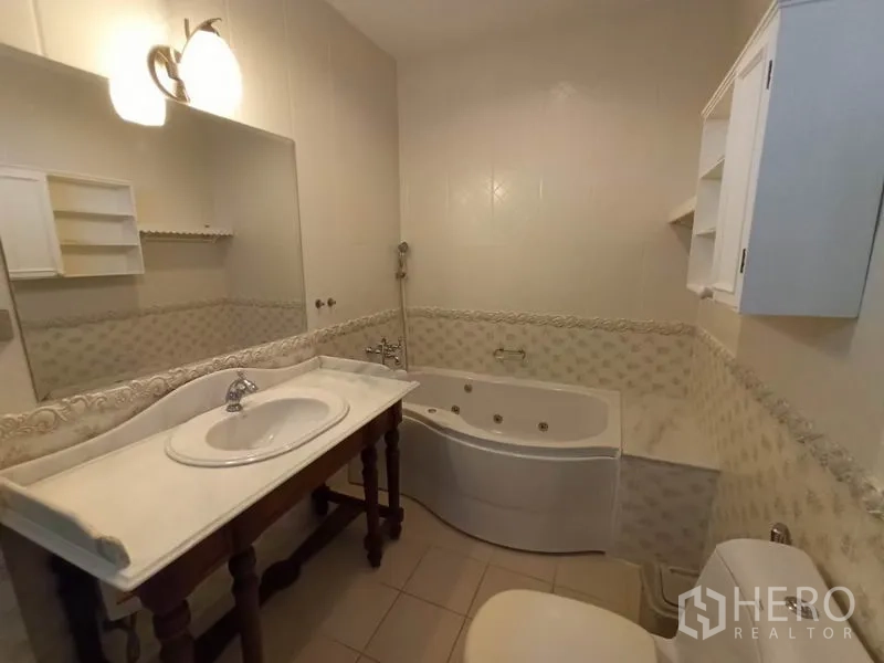 Detached House for rent in Mueang Samut Prakan, Samut Prakan - Bathroom with vanity, jetted bathtub and light neutral tiles.