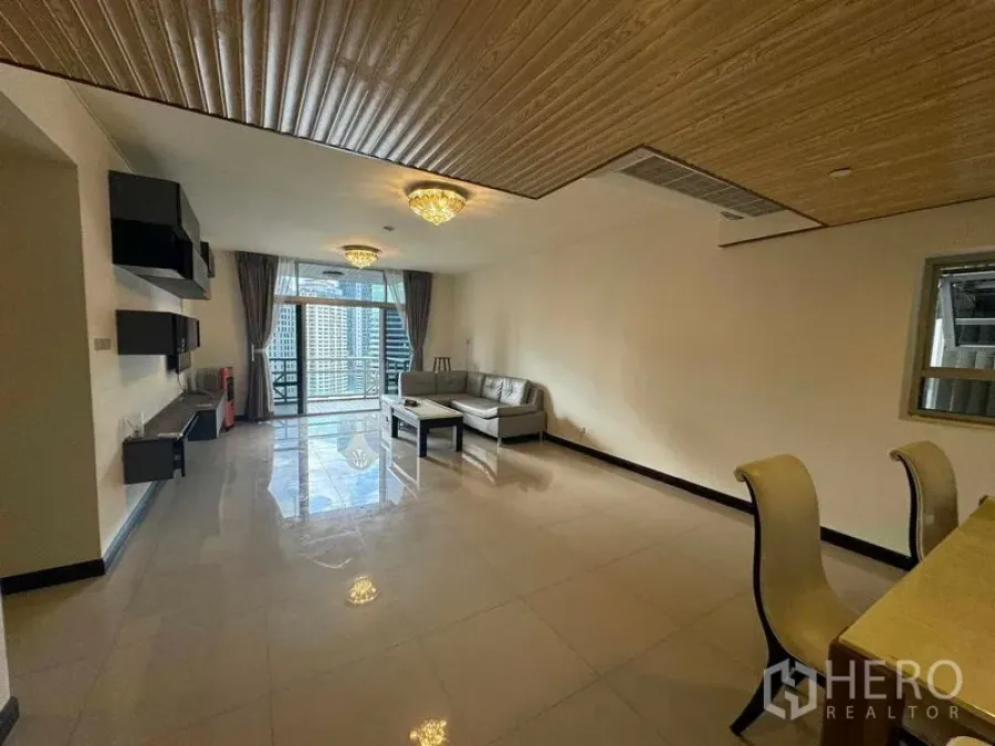 Condominium for rent in Pathum Wan, Bangkok - Wide view of the living and dining space leading to a balcony with skyline backdrop.