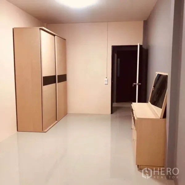 Townhouse for rent or sale in Huai Khwang, Bangkok - Bright bedroom with glossy tile floor, large wardrobe and dressing table.