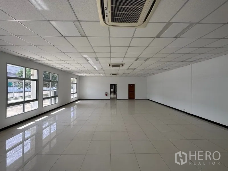 Factory for rent in Bang Sao Thong, Samut Prakan - Bright office space with tiled floors, drop ceiling, and large windows.