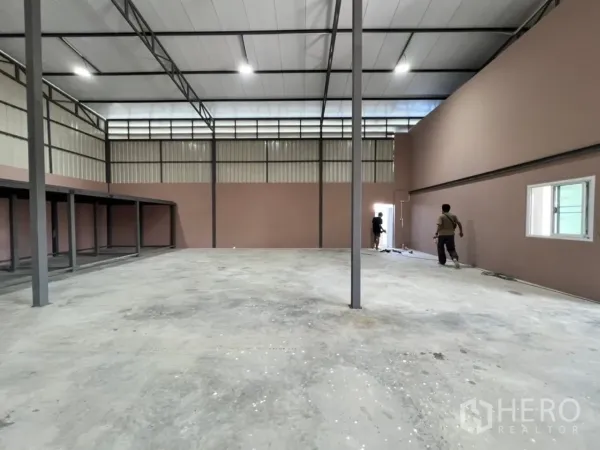 Warehouse for rent in Bang Bua Thong, Nonthaburi - Large clear-span warehouse floor with steel columns and bright roof lighting.