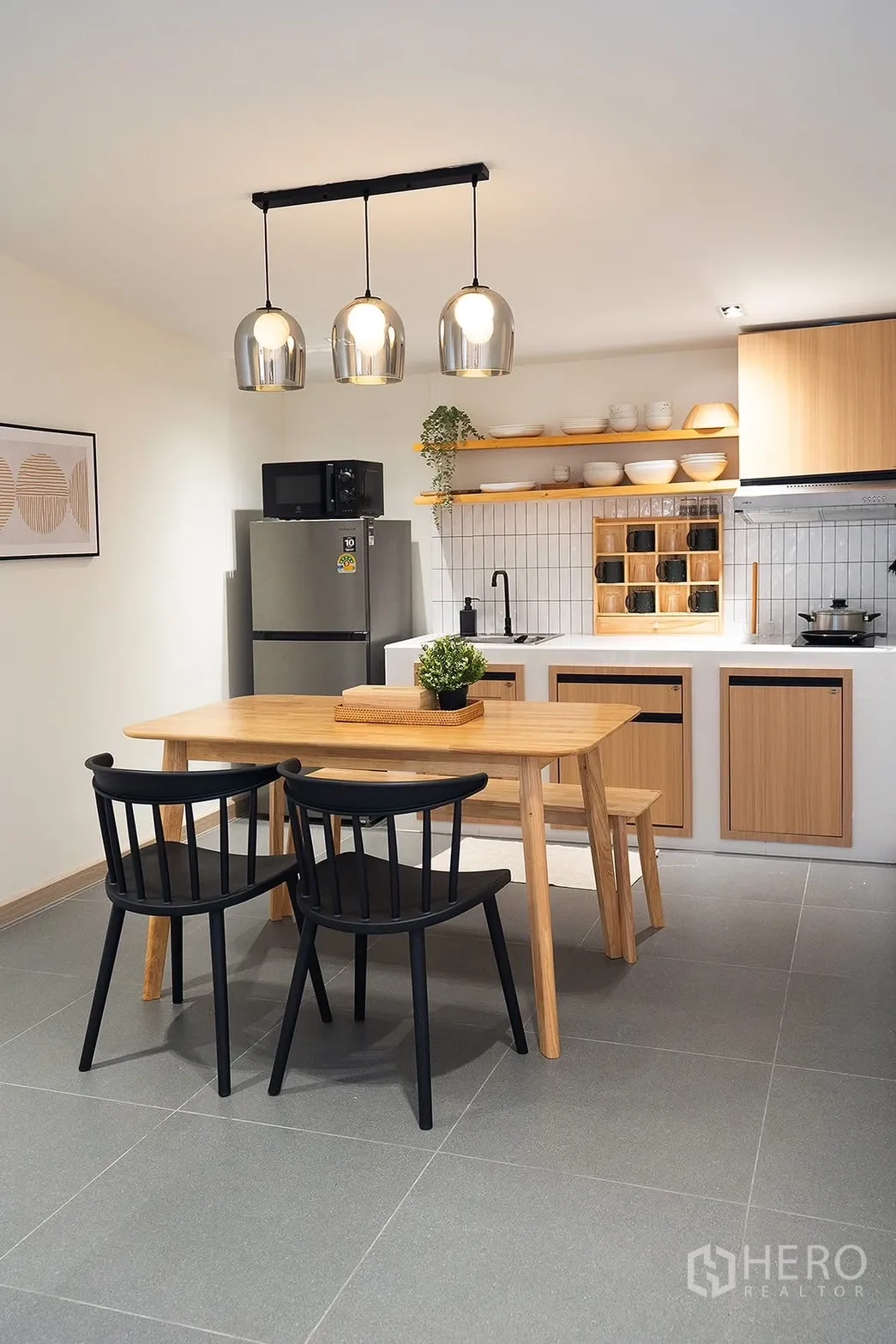 Detached House for rent in Huai Khwang, Bangkok - Open kitchen with wood cabinets, tiled backsplash and dining table with bench.